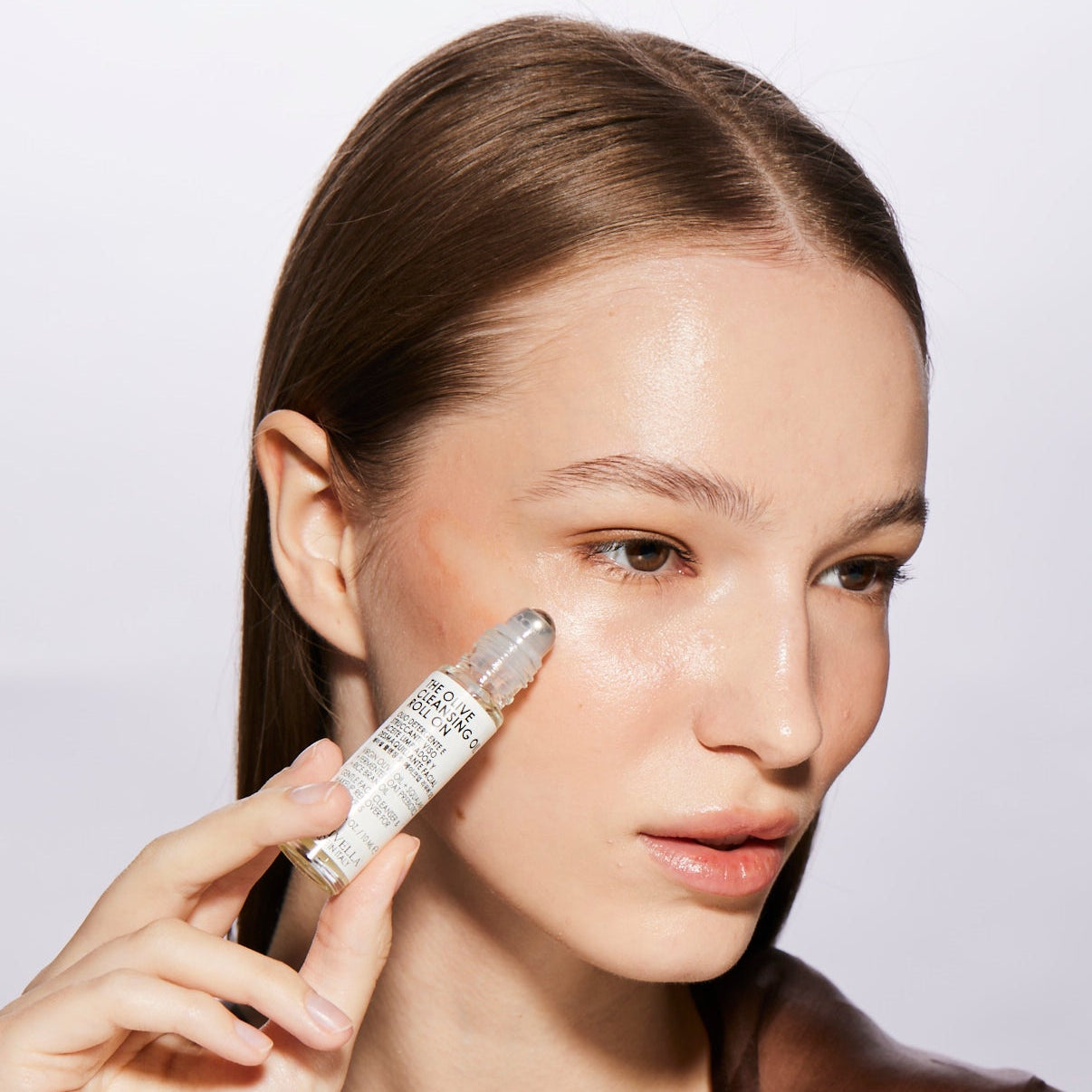 Woman Applying Olivella Cleansing Oil Roll-on
